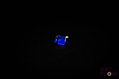 une image représentant un anneau bleu dans l'obscurité, éclairé par une lumière