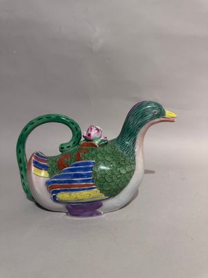 a small teapot with a bird on top of it