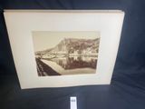 an old photo of a bridge over a river with a mountain in the background