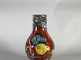 un vase rouge orné d'un motif de poisson