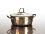 une casserole en argent avec un couvercle, posée sur une table
