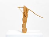 a sculpture made of wood on a white pedestal