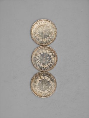 three silver coins sitting on top of each other on a table