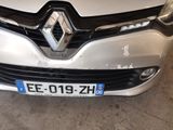 the front end of a white car with a number plate on it