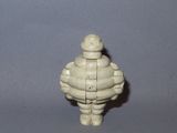 a small white figurine of a man with a hat on