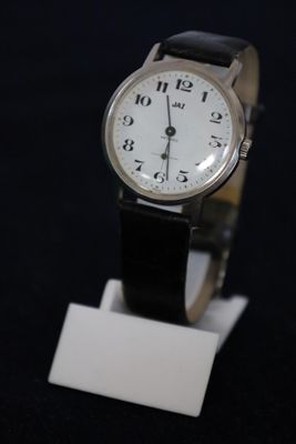 a watch that is sitting on a stand on a black surface
