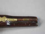 a wooden case with a brass handle on a white surface