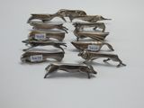 six figurines de chiens plaquées argent sur un fond blanc