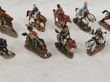many figurines of men riding horses on a white surface