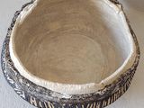 a black and white bowl sitting on a white surface