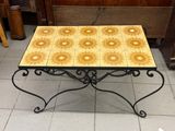 a small table with a yellow and white tile on it