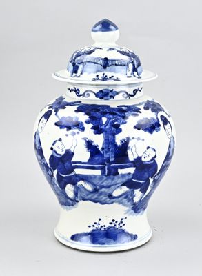 a blue and white vase with a lid on a table