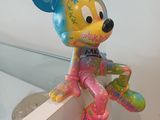 a colorful mickey mouse balloon hanging from a wall