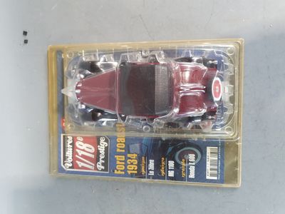 a red toy car in a plastic box on a table