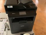 une imprimante posée sur une table, à côté d'autres fournitures de bureau