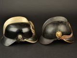 two helmets are sitting side by side on a black surface