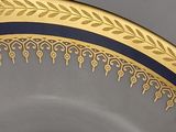 a close up of a plate with a gold border