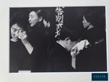 a black and white photo of a group of people eating