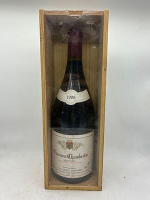 une vieille bouteille de vin dans une caisse en bois posée sur une surface blanche