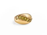 a close up of a gold ring with green stones