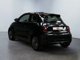 the back of a black car is parked in a large room