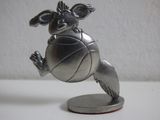 une figurine en argent représentant un chien jouant avec un ballon de basket