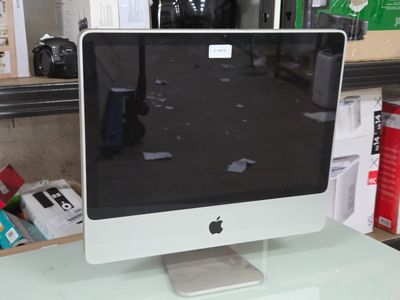 un écran d'ordinateur posé sur un bureau blanc