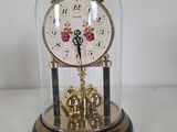 a clock inside of a glass dome on a table