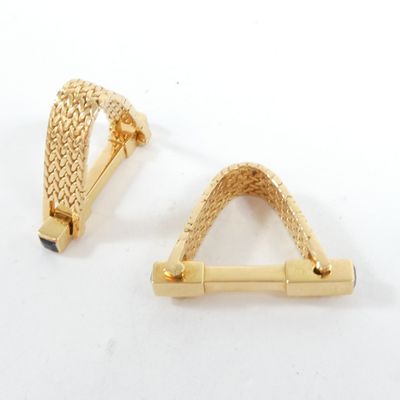 paire de boucles d'oreilles dorées ornées de motifs tressés sur fond blanc