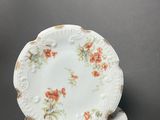 two white plates with orange flowers are stacked on top of each other