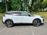 the white suv is parked in a parking lot with trees in the background