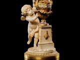 statue de Cupidon tenant une horloge, posée sur un socle, sur fond noir