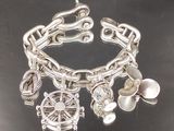 un bracelet en argent orné de breloques, posé sur un fond noir