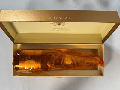 a bottle of champagne in a gold box on a table