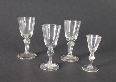 quatre verres à vin transparents posés sur une table noire