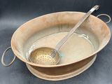a brown bowl with a spoon in it on a table
