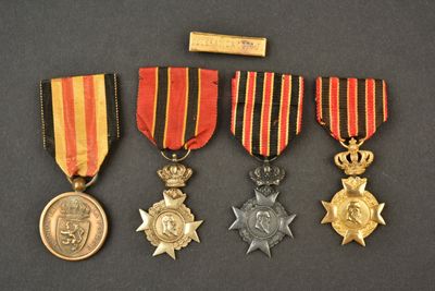 trois médailles et une médaille posée sur une table, avec un bâton en bois