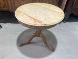 a marble top table on a pedestal in a room