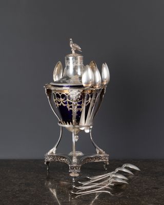 un vase argenté et bleu orné de cuillères