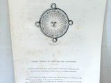 un vieux livre posé sur une table, avec une boussole dessus