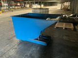 a blue dumpster sitting in a warehouse with pallets
