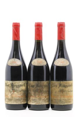 trois bouteilles de vin rouge posées l'une à côté de l'autre sur une surface blanche
