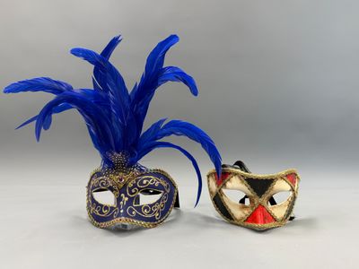 deux masques de bal masqué ornés de plumes bleues sur fond blanc