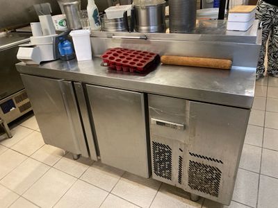 a large stainless steel counter in a kitchen with a bunch of utensils on it