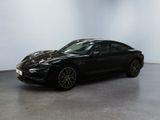 the black porsche 911 is parked in a white room