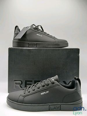 the black sneakers are in a box on a white surface