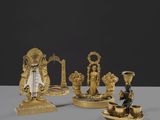 Trois figurines en or sont posées les unes à côté des autres sur une table