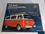 un minibus Volkswagen orange avec une planche de surf sur le toit