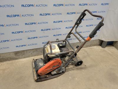 un gros plan d'une petite tondeuse à gazon posée sur un sol en béton