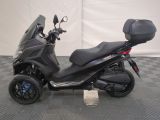 the motor scooter is parked on a checkered tile floor